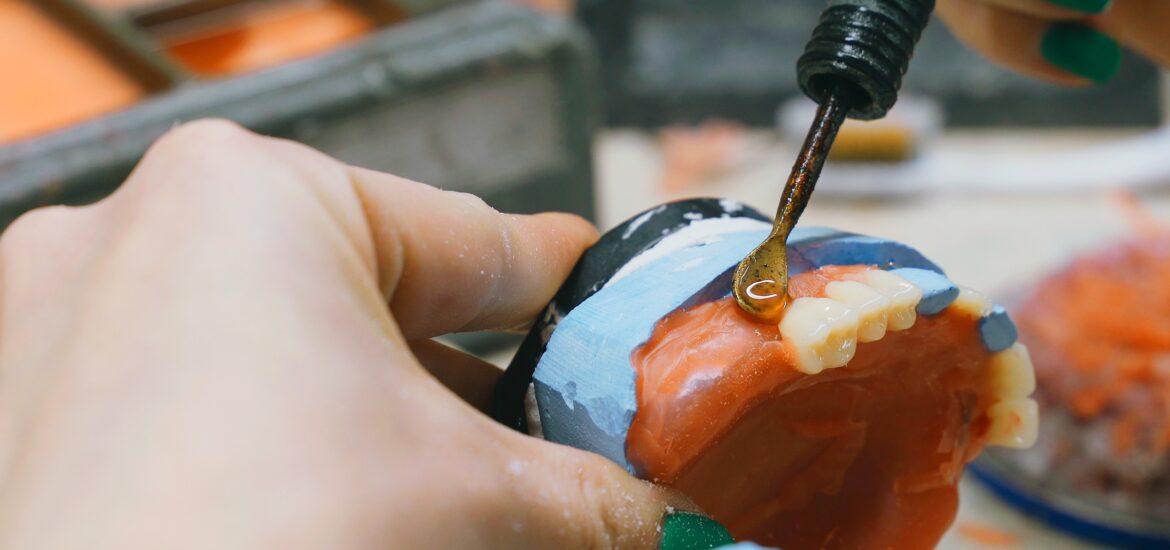 dentist customizing a pair of cosmetic dentures