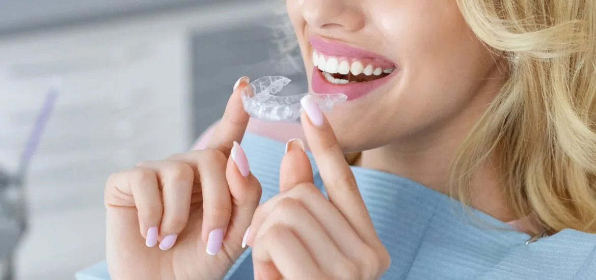closeup of an adult woman putting in her clear aligners