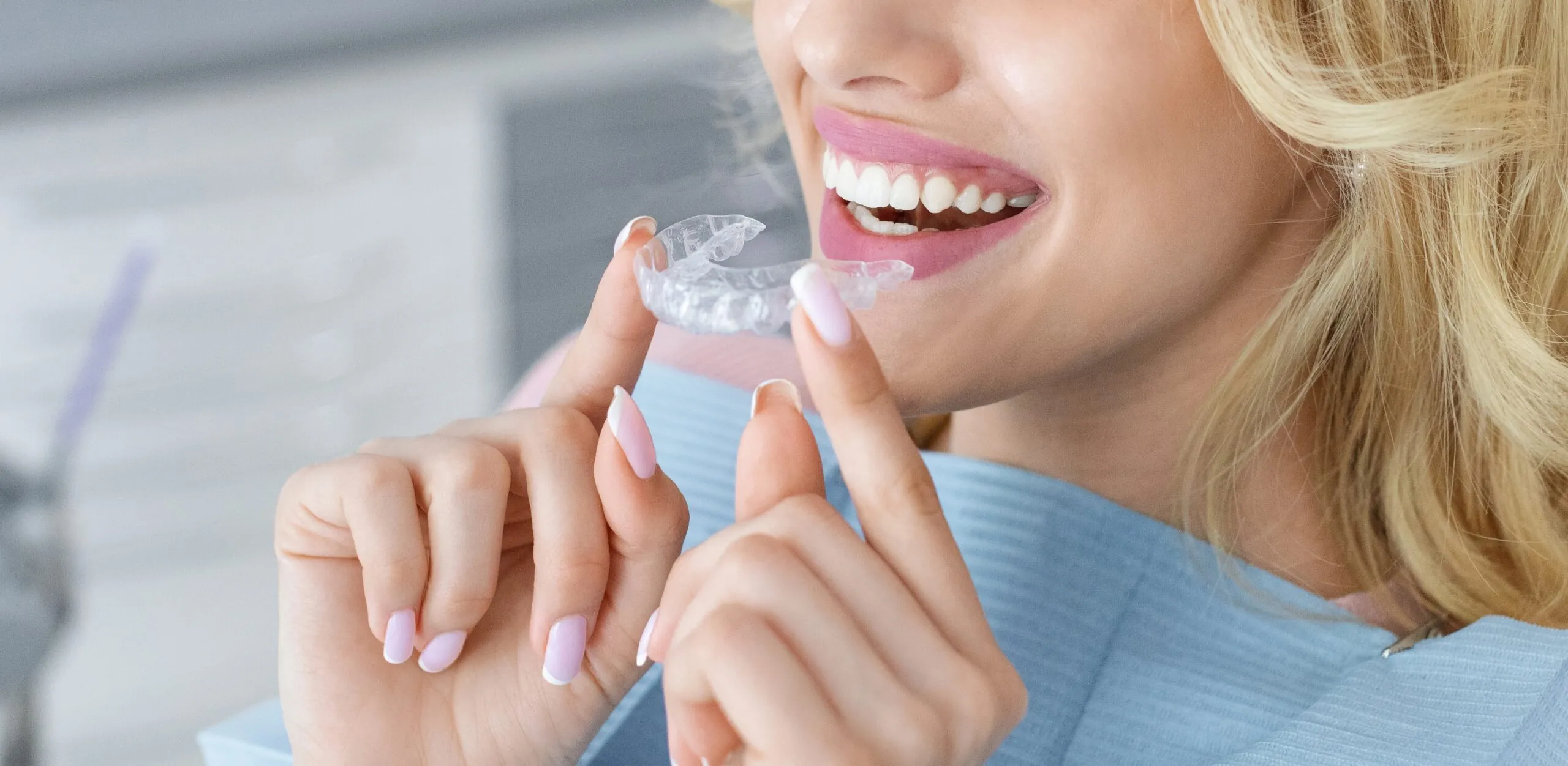 closeup of an adult woman putting in her clear aligners