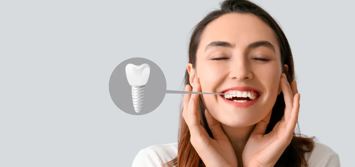 Beautiful happy young woman with implanted tooth on light background