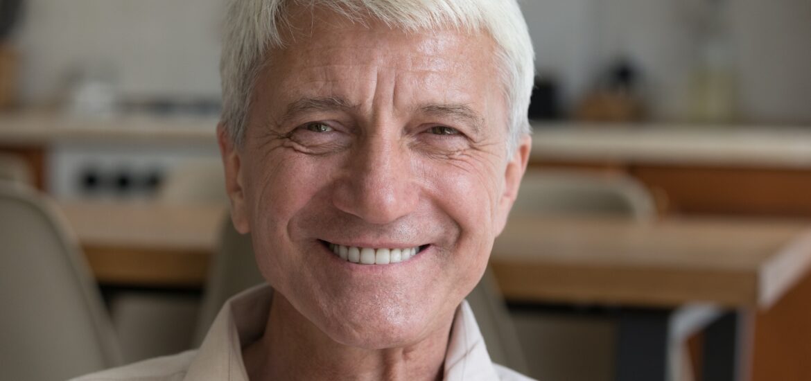 head shot of an older man with new natural looking veneers