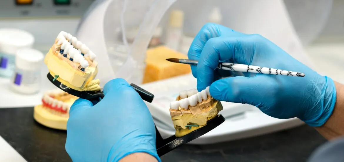 Dental prosthesis work. Denture work. Teeth painting. Dental technician working with tooth denture at prosthesis laboratory