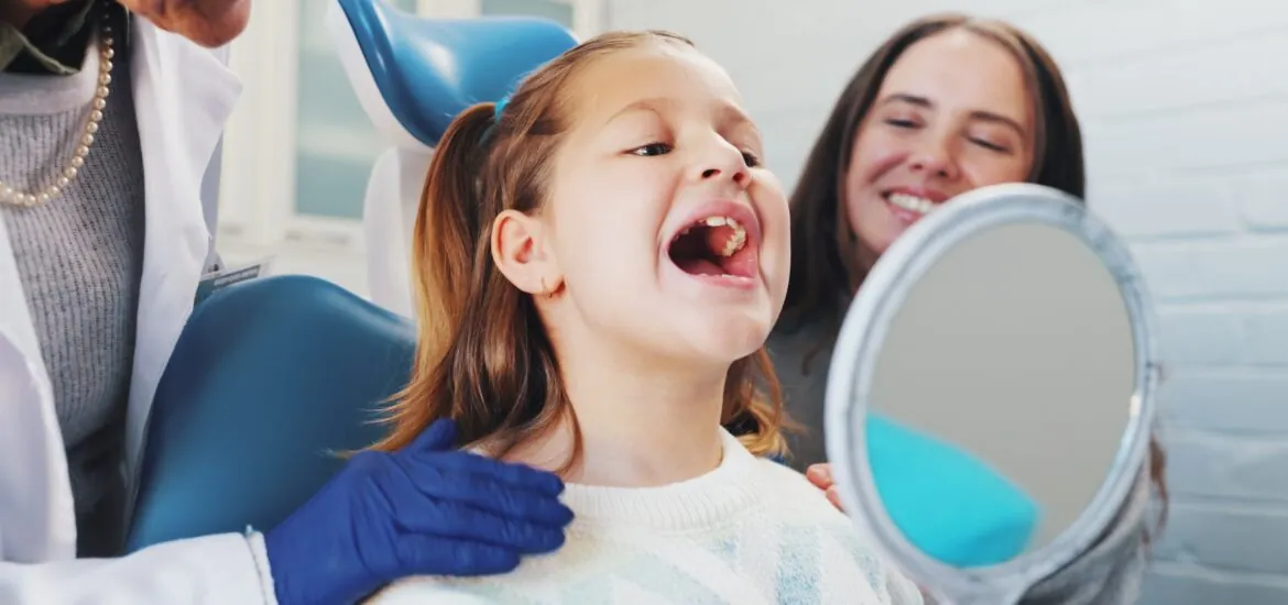 happy little girl having her teeth checked